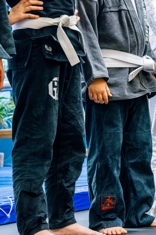 Nuoria kamppailusalin treenivaatteissa.